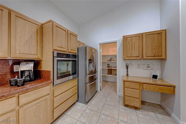 kitchen featuring light tile patterned flooring, light brown cabinetry, and appliances with stainless steel finishes