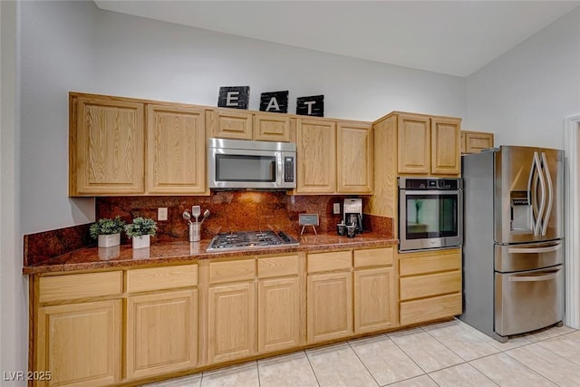 kitchen featuring stainless steel appliances, light brown cabinets, decorative backsplash, and light tile patterned floors