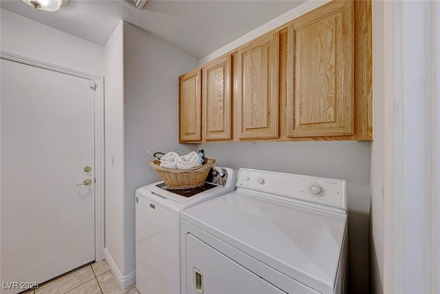 laundry area with cabinets, separate washer and dryer, and light tile patterned floors