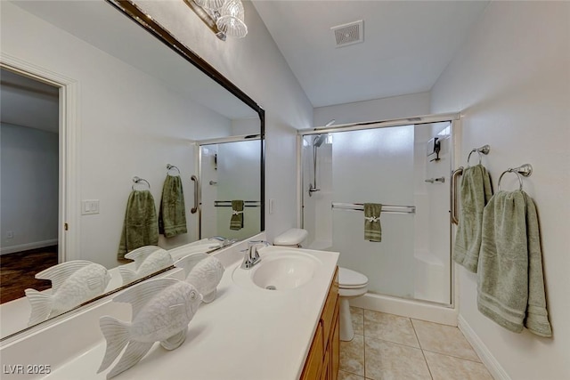 bathroom featuring vanity, tile patterned flooring, toilet, and a shower with shower door