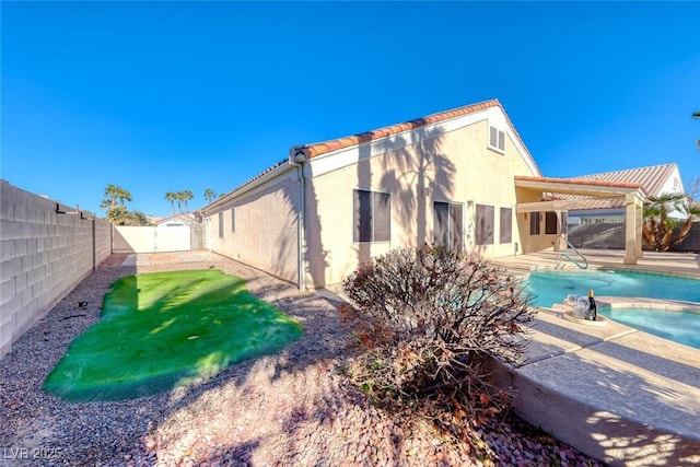 back of house featuring a pergola, a patio, and a fenced in pool