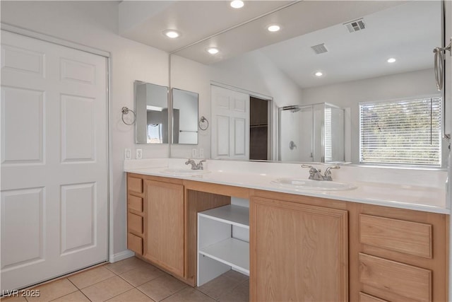 bathroom featuring a shower with door, vanity, and tile patterned floors