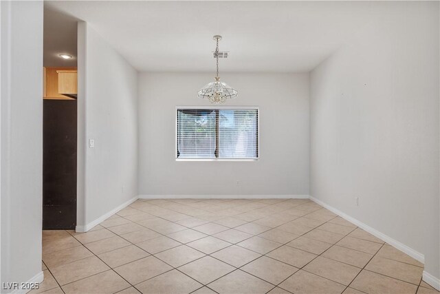 tiled empty room featuring a notable chandelier