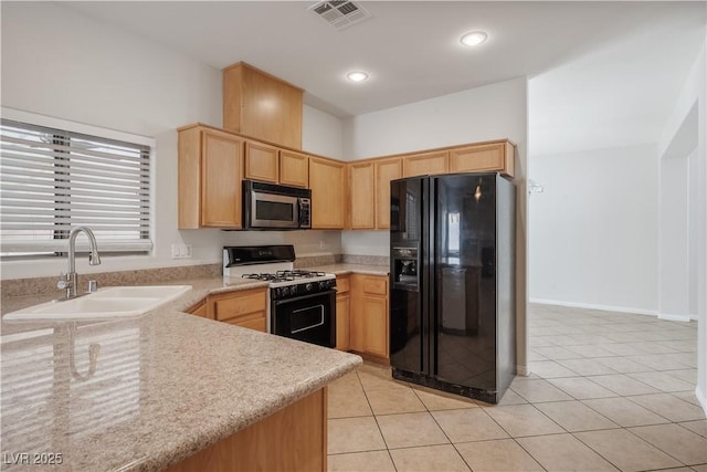 kitchen featuring gas range oven, black fridge with ice dispenser, sink, light tile patterned flooring, and light brown cabinets