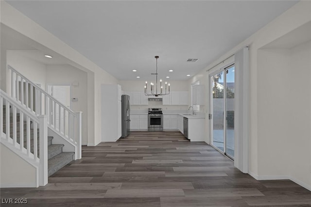 kitchen with pendant lighting, stainless steel appliances, dark hardwood / wood-style flooring, white cabinets, and sink