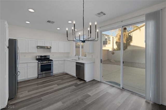 kitchen with stainless steel appliances, white cabinets, sink, and hardwood / wood-style flooring