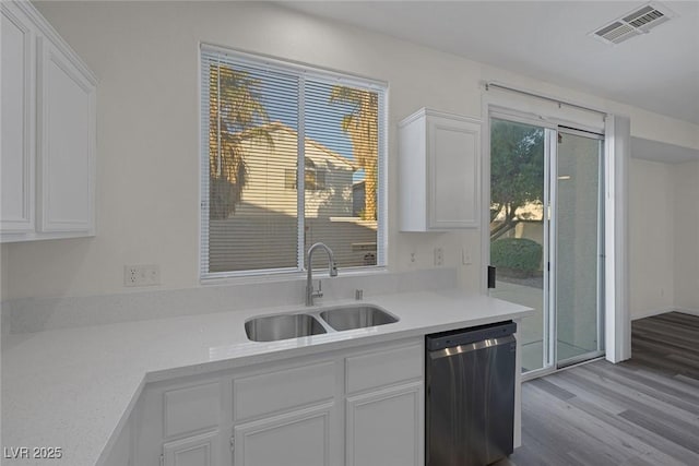 kitchen with sink, light hardwood / wood-style flooring, white cabinetry, and stainless steel dishwasher