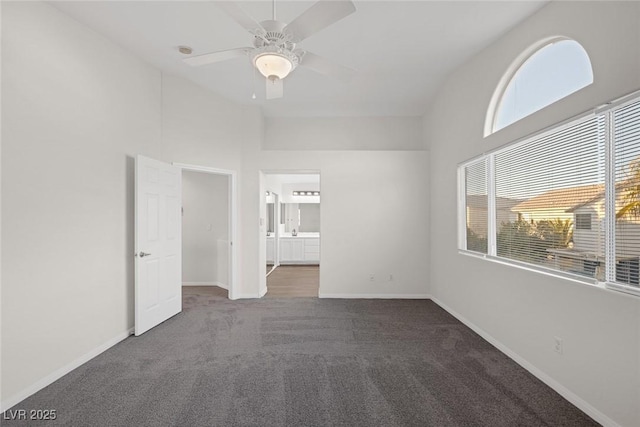 carpeted empty room featuring high vaulted ceiling, ceiling fan, and plenty of natural light