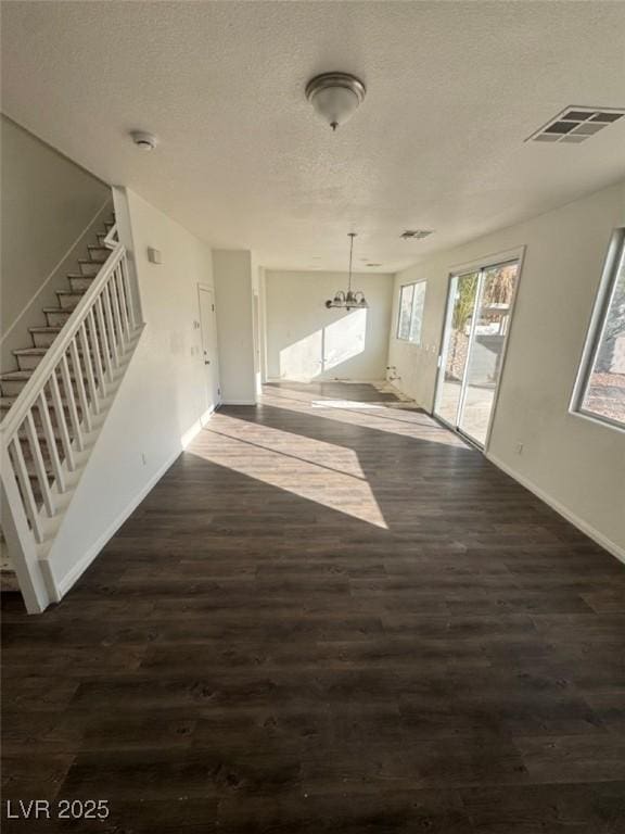 unfurnished living room with dark wood-type flooring and a textured ceiling