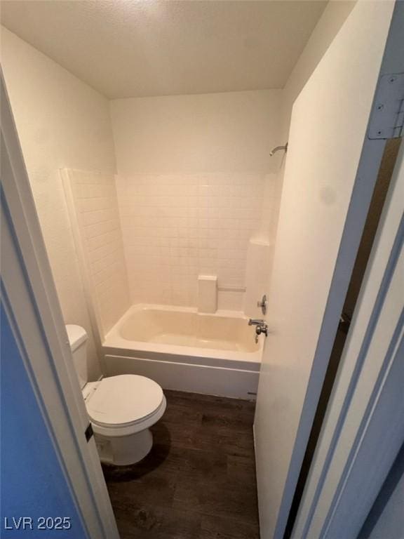 bathroom with shower / bathing tub combination, toilet, and wood-type flooring