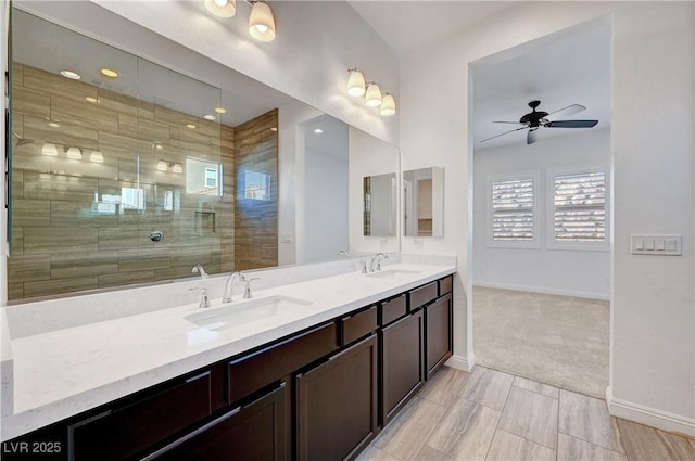 bathroom with ceiling fan, tiled shower, and vanity