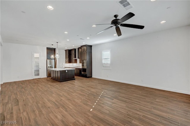 unfurnished living room featuring ceiling fan, dark hardwood / wood-style floors, and sink