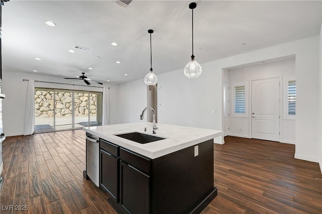 kitchen with ceiling fan, pendant lighting, sink, a healthy amount of sunlight, and an island with sink