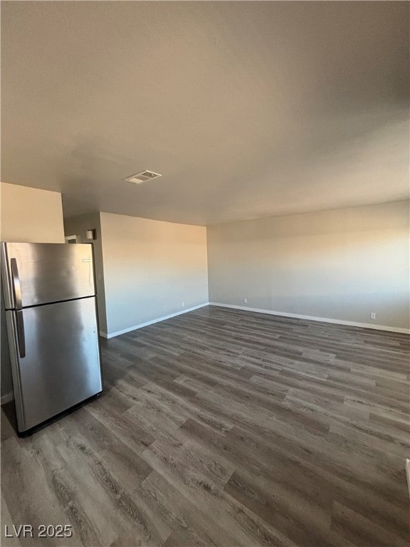 interior space featuring stainless steel fridge and dark hardwood / wood-style floors