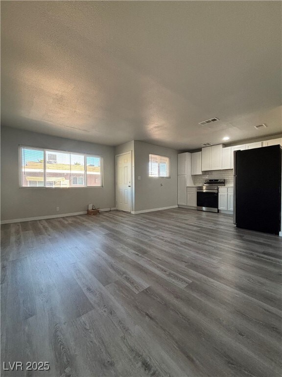 unfurnished living room with a textured ceiling and hardwood / wood-style floors