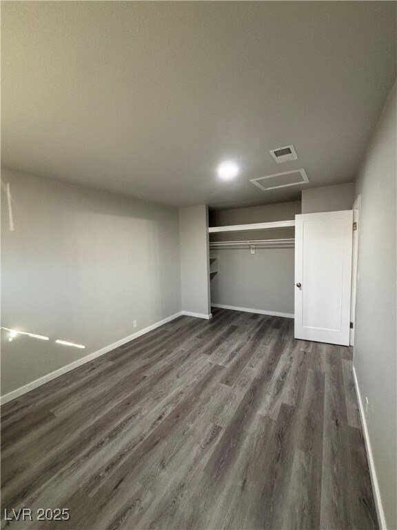 unfurnished bedroom featuring a closet and dark hardwood / wood-style floors