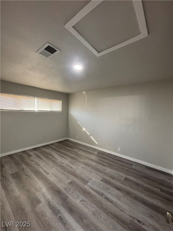 unfurnished room with dark wood-type flooring