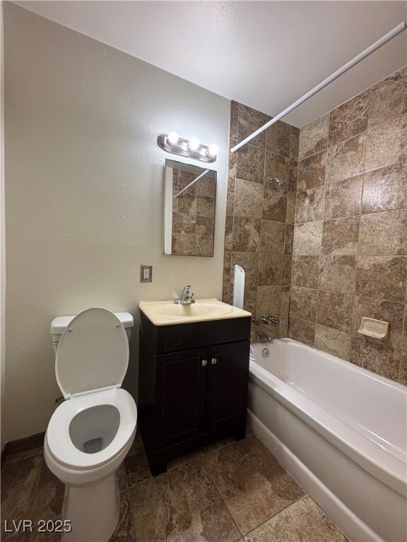 full bathroom with toilet, vanity, and tiled shower / bath