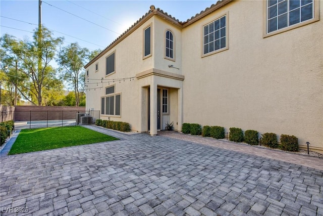 rear view of property featuring cooling unit, a patio area, and a yard