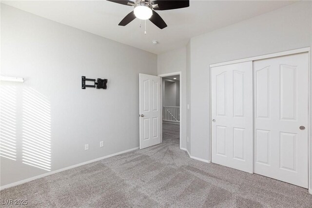 unfurnished bedroom featuring a closet, ceiling fan, and light colored carpet