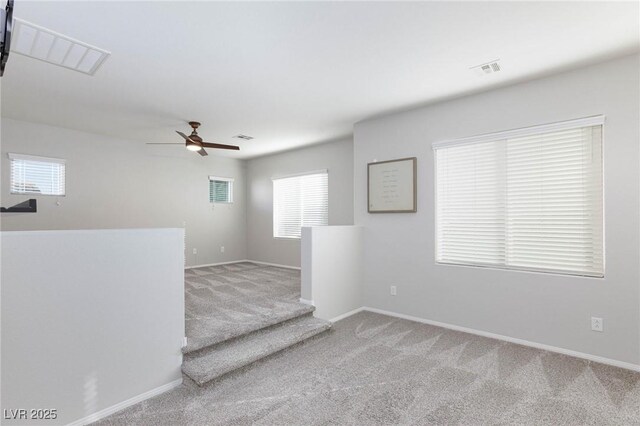 empty room featuring carpet, ceiling fan, and a healthy amount of sunlight