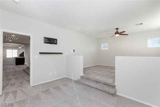 carpeted spare room with ceiling fan