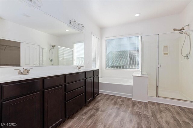 bathroom featuring plus walk in shower, vanity, and hardwood / wood-style flooring