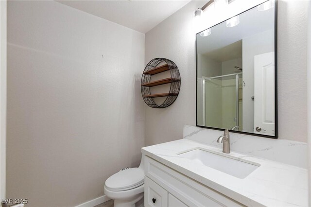 bathroom with toilet, vanity, and walk in shower