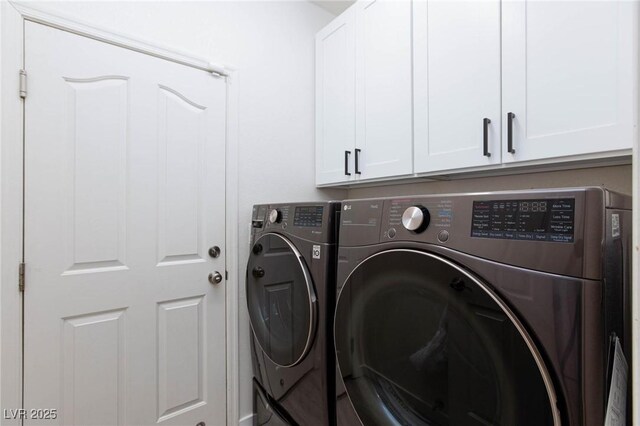 laundry area featuring washing machine and clothes dryer and cabinets