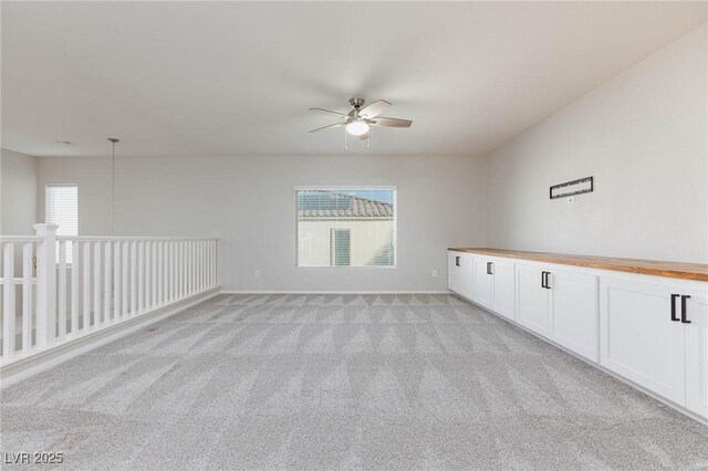 spare room with light carpet, ceiling fan, and a wealth of natural light