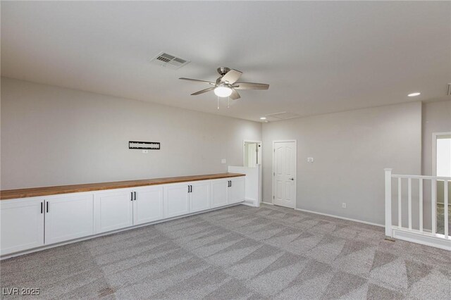 unfurnished room featuring ceiling fan and light colored carpet