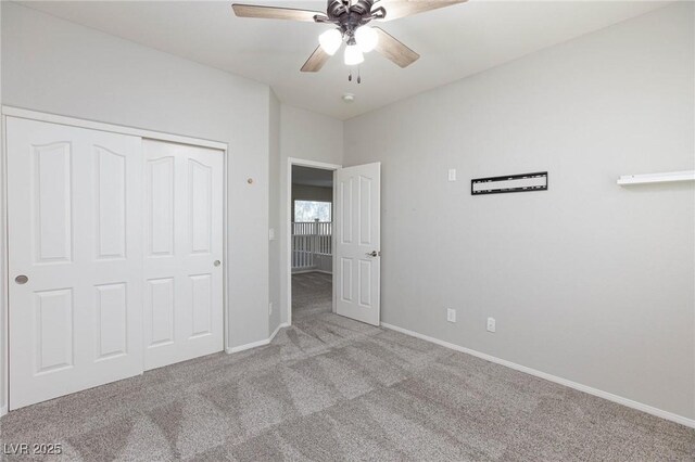 unfurnished bedroom featuring ceiling fan, a closet, and light carpet