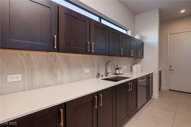 kitchen featuring light tile patterned flooring, dishwasher, dark brown cabinets, and sink