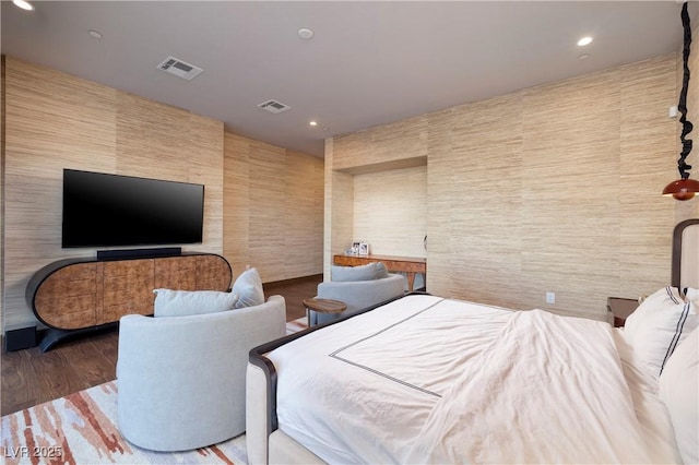 bedroom featuring wood-type flooring and tile walls