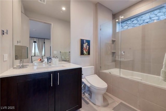 full bathroom with toilet, tiled shower / bath combo, and vanity