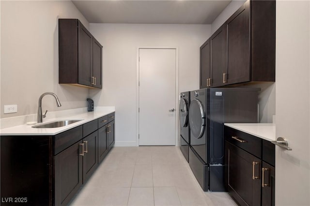 clothes washing area featuring sink, cabinets, separate washer and dryer, and light tile patterned floors