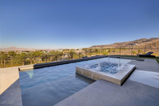 view of swimming pool with a jacuzzi and a mountain view