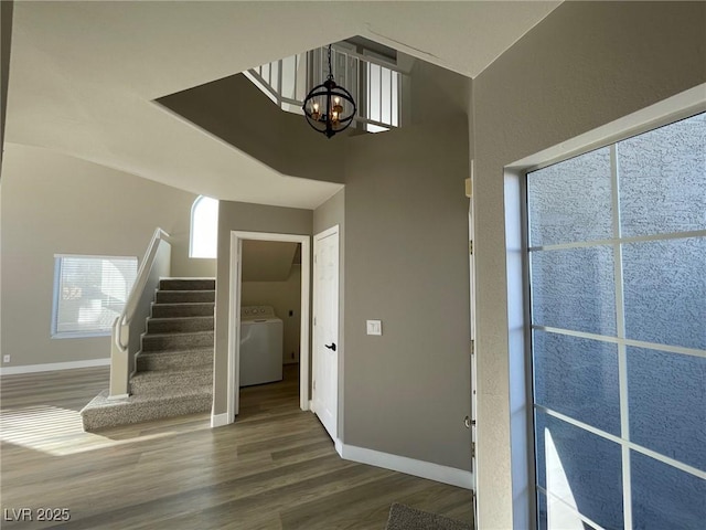 interior space with washer / dryer, dark wood-type flooring, and an inviting chandelier