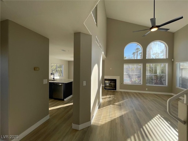 unfurnished living room featuring sink, ceiling fan, plenty of natural light, and dark hardwood / wood-style floors