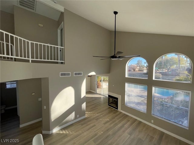 living room featuring ceiling fan, high vaulted ceiling, and hardwood / wood-style flooring