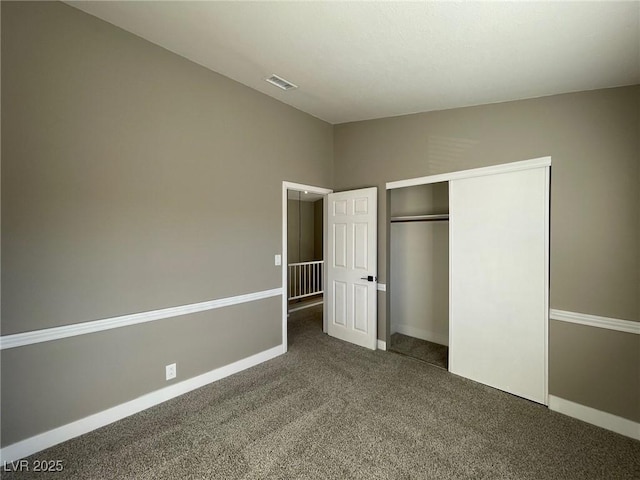 unfurnished bedroom featuring a closet and dark colored carpet