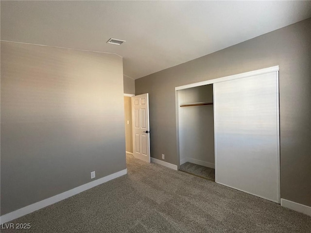 unfurnished bedroom featuring a closet, vaulted ceiling, and carpet flooring