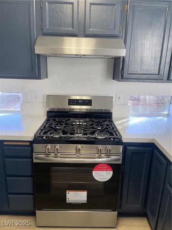 kitchen with stainless steel range with gas cooktop and blue cabinetry