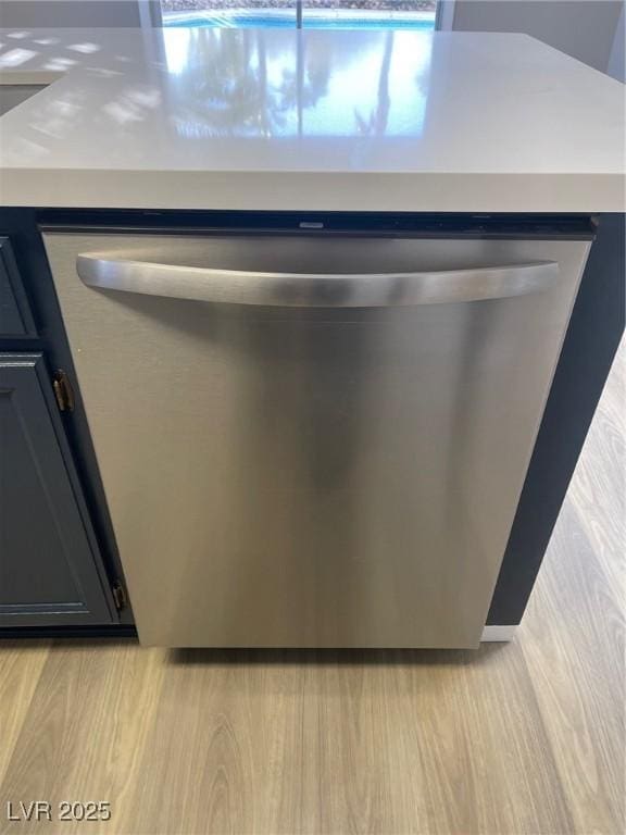 details with stainless steel dishwasher and light wood-type flooring