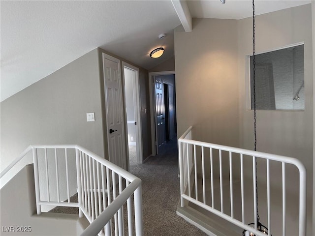 hall featuring dark colored carpet and lofted ceiling with beams