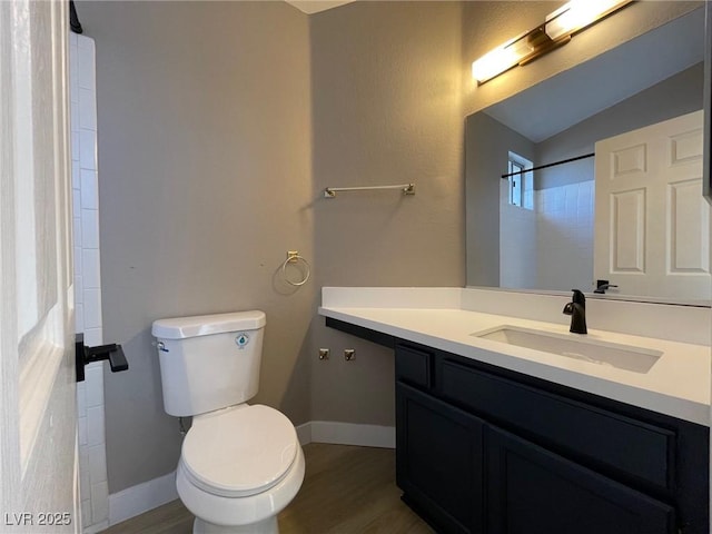 bathroom with toilet, vanity, hardwood / wood-style flooring, and walk in shower