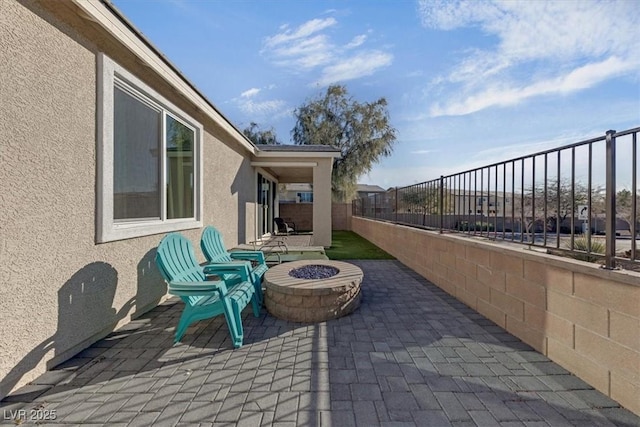 view of patio featuring an outdoor fire pit and a fenced backyard