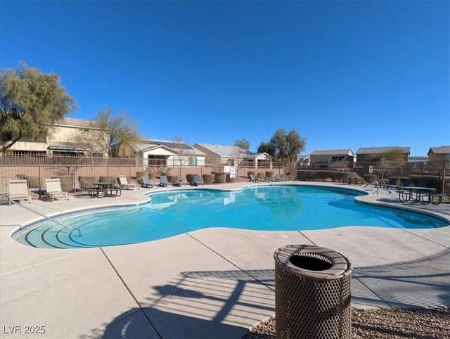 community pool featuring a residential view, fence, and a patio