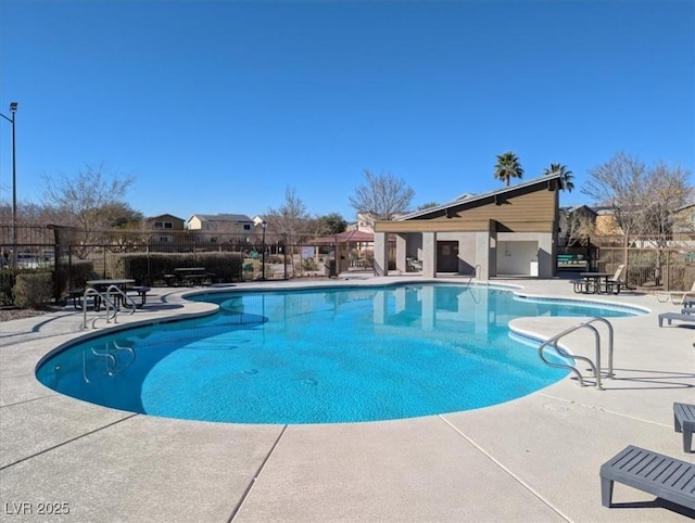 community pool featuring fence and a patio