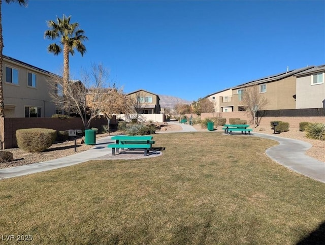 view of property's community with a residential view, fence, and a yard